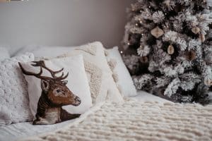 Cama decorada con cojines y juguetes navideños.