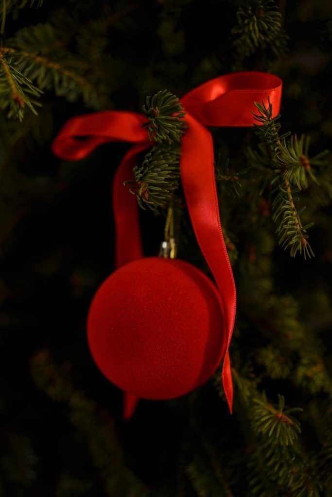 adorno navideño rojo con una cinta de terciopelo