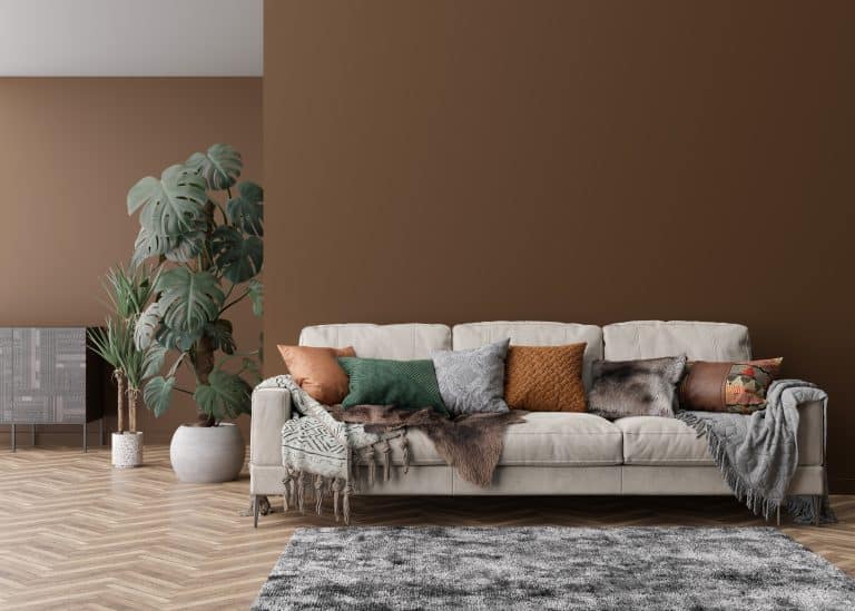 Empty brown wall in modern living room. Mock up interior in contemporary style. Free, copy space for picture, poster, text, or another design. Sofa, sideboard, carpet, plants. 3D rendering
