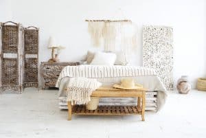 Cómoda cama con dosel y almohadas mullidas situada en un dormitorio minimalista y luminoso dentro de un apartamento moderno.