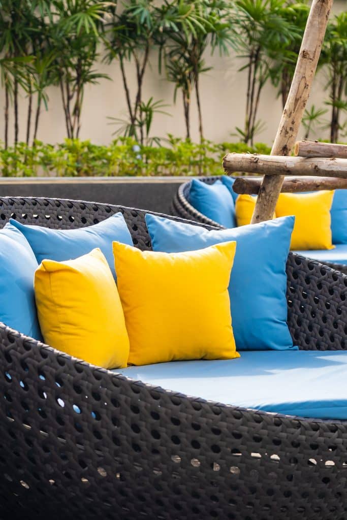 Terraza exterior en el jardín con sillón y cojines decorativos