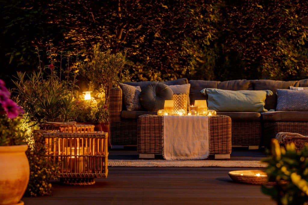 lámparas, faroles y velas de última tendencia en el jardín por la noche
