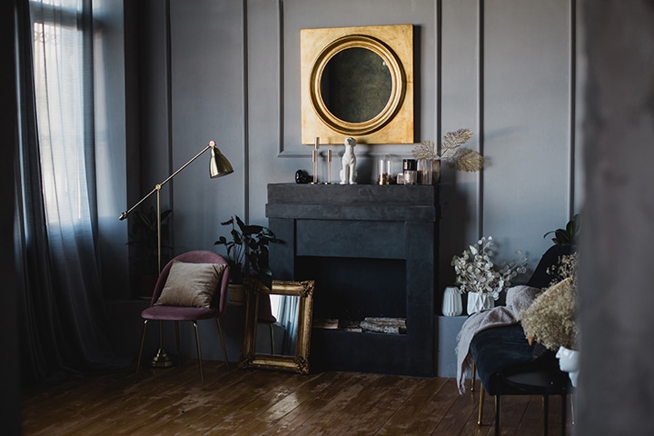 salón-en-negro-con-una-chimenea-decorativa-y-un-espejo