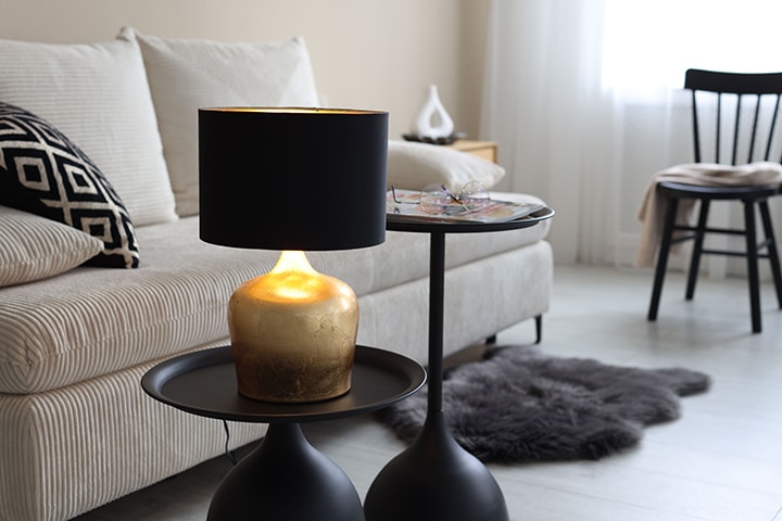 Lámpara elegante en negro sobre una mesa junto al sofá